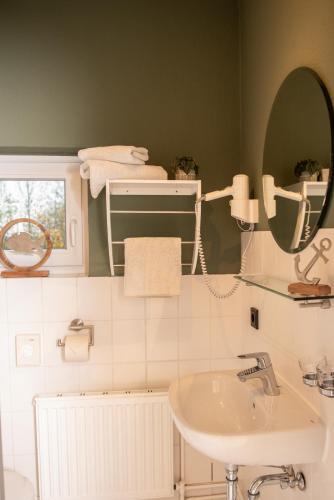 a bathroom with a sink and a mirror at Das Anni's in Wangerland