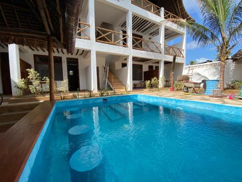 a swimming pool in front of a house at Zuzanu house in Nungwi