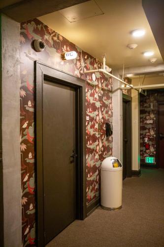 a hallway with a door and a wall with flowers at KEX Hotel in Portland