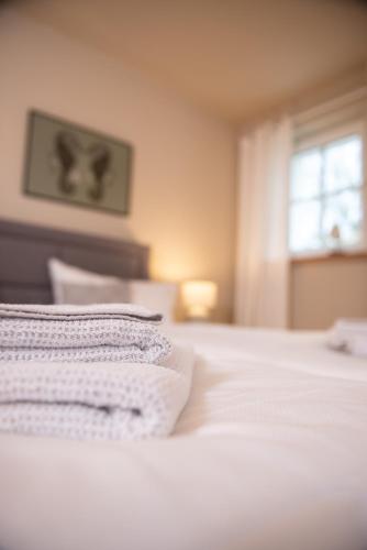 a bedroom with a white bed with a window at Das Anni's in Wangerland