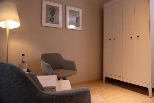 a living room with two chairs and a cabinet at Das Anni's in Wangerland