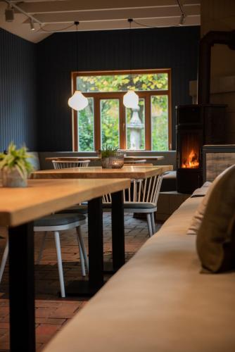 a dining room with a table and chairs and a fireplace at Das Anni's in Wangerland