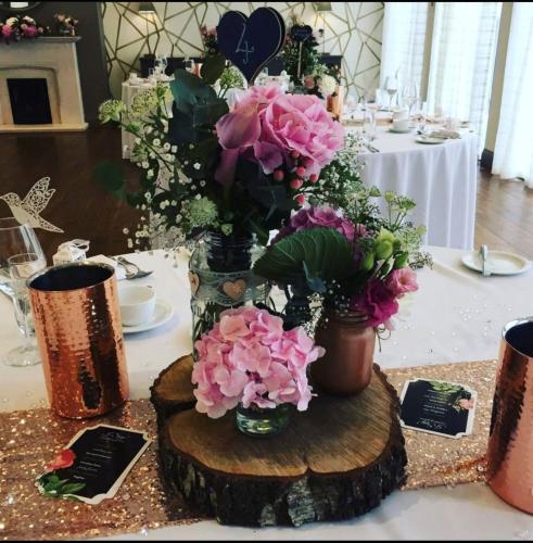a table with a vase of flowers on a wooden stump at The Orchid Hotel in Bournemouth