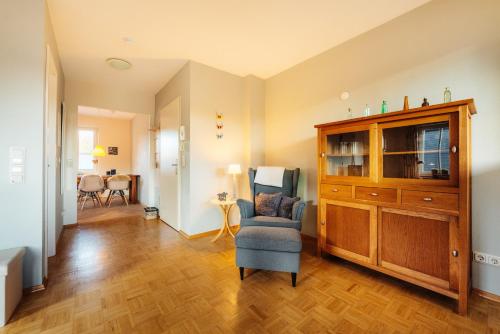 a living room with a chair and a cabinet at Wintergartenhaus Braunlage in Braunlage