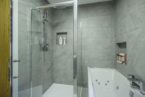 a bathroom with a shower and a bath tub at Vion Apartment- Westerton in Aberdeen