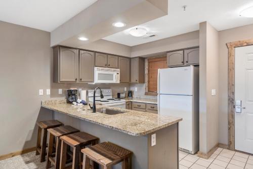 a kitchen with wooden cabinets and a white refrigerator at Table Rock Resorts at Indian Point in Branson