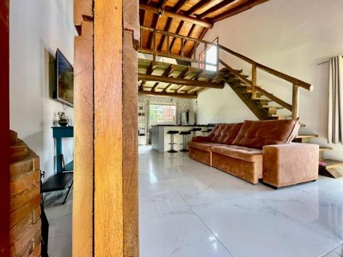a living room with a couch and a staircase at chalé da reserva com piscina in Torres