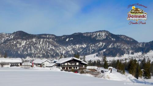 eine Skihütte im Schnee mit Bergen im Hintergrund in der Unterkunft Hotel-Gasthof-Sonneck in Reit im Winkl
