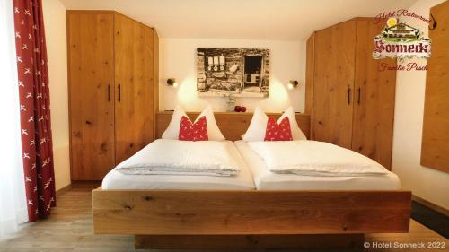 ライト・イム・ヴィンクルにあるHotel-Gasthof-Sonneckのベッドルーム(ベッド2台、木製キャビネット付)