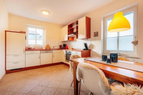 une cuisine avec une table et une lampe jaune dans l'établissement Wintergartenhaus Braunlage, à Braunlage