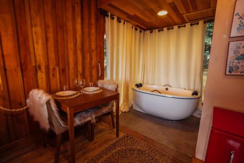 a bath tub in a room with a table and a tableablish at Montanha Home in Monte Verde