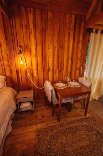 a bedroom with a bed and a table in a room at Montanha Home in Monte Verde