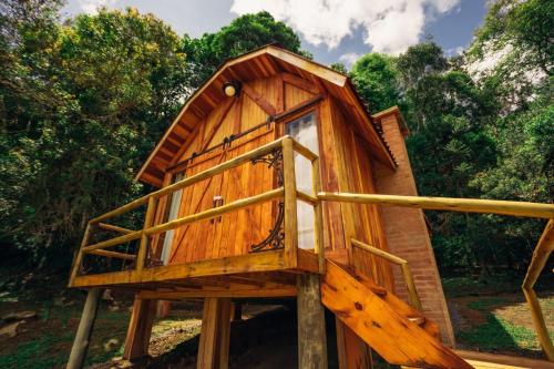 a tree house sitting on a wooden platform at Montanha Home in Monte Verde