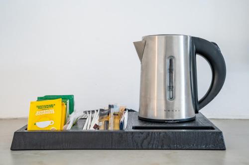 a coffee pot is sitting on a black stand at Poseidon Blue Gastronomy Hotel in Afiartis