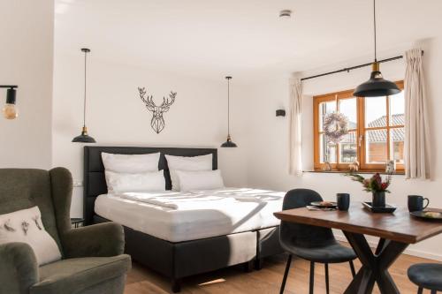 une chambre avec un lit, une table et une chaise dans l'établissement Alpenblüte, à Reit im Winkl