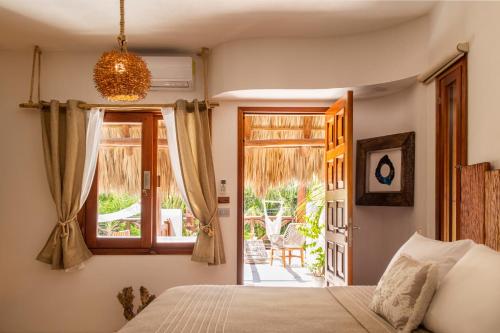 1 dormitorio con 1 cama y puerta que da a un patio en El Corazón Boutique Hotel - Adults Only with Beach Club's pass included, en Isla Holbox