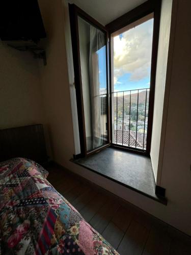 a bedroom with a bed and a window with a view at Hotel Centrale in Cascia