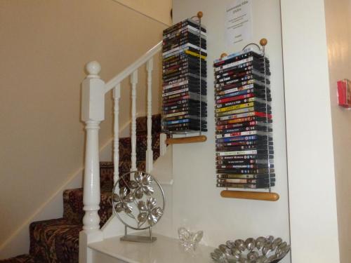 a staircase with cds and dvds on the stairs at Launceston Villa in Whitby