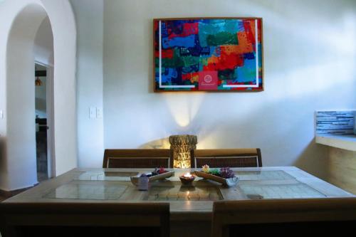 a dining room table with a painting on the wall at Santuario Playa in Playa del Carmen