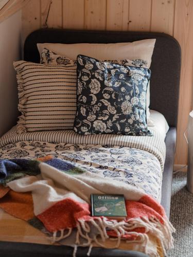 a bed with a bunch of blankets and pillows at Owczarnia Tatry in Bukowina Tatrzańska