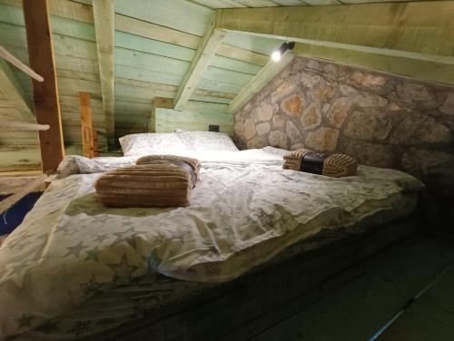 a large bed in a room with a stone wall at Stone House Montenegro in Danilovgrad