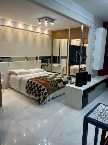 um quarto com uma cama e um espelho grande em Loft com vista incrível para a Praia da Costa! em Vila Velha