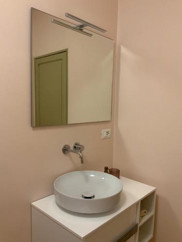 a bathroom with a white sink and a mirror at Appartamento Biò in Borgofranco dʼIvrea