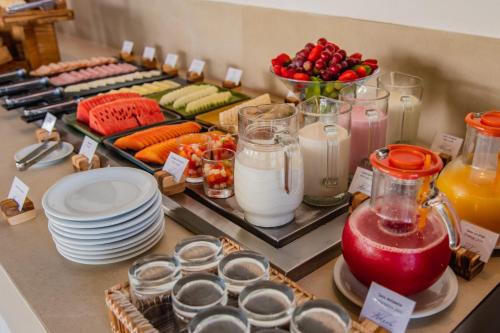 a buffet with plates of food and fruits and vegetables at Pousada Aldeola by Slaviero Hotéis in Baixio