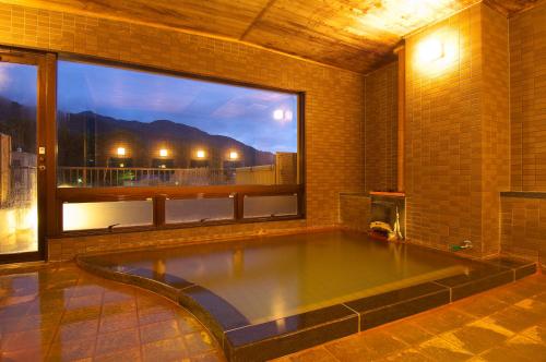 una piscina en una habitación con una ventana grande en Ichinoyu Katei, en Yamanouchi