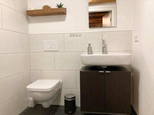 a white bathroom with a sink and a toilet at PEARLs - Stilvolle Wohnung zwischen dem Schwarzwald & der Schweiz in Stühlingen