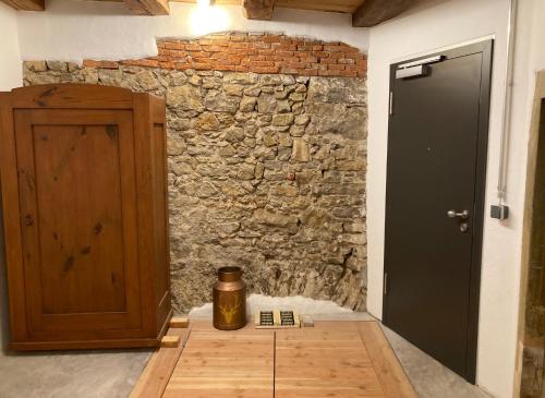 a room with a stone wall next to a door at PEARLs - Stilvolle Wohnung zwischen dem Schwarzwald & der Schweiz in Stühlingen