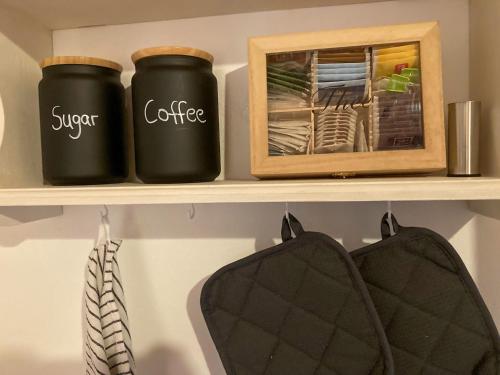 two black jars on a shelf with a box at PEARLs - Stilvolle Wohnung zwischen dem Schwarzwald & der Schweiz in Stühlingen