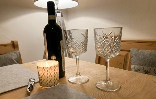three wine glasses sitting on a table with a bottle of wine at PEARLs - Stilvolle Wohnung zwischen dem Schwarzwald & der Schweiz in Stühlingen