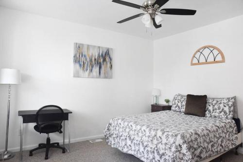 a bedroom with a bed and a desk and a ceiling fan at Perfect Mount Washington Home Walkable w Parking in Pittsburgh