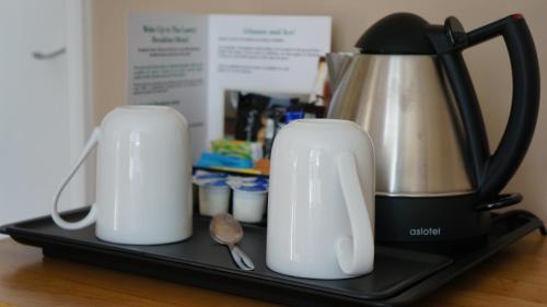 a black and silver appliance sitting on a black tray at The Lawn Guest House Gatwick in Horley