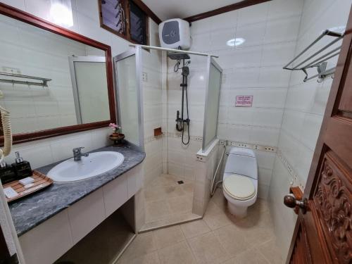 a bathroom with a sink and a toilet and a mirror at Khampiane1 Hotel in Ban Nongdouang