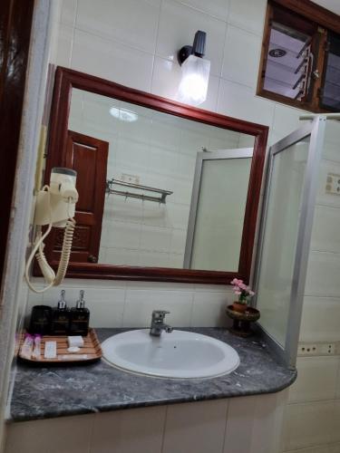 a bathroom with a sink and a large mirror at Khampiane1 Hotel in Ban Nongdouang