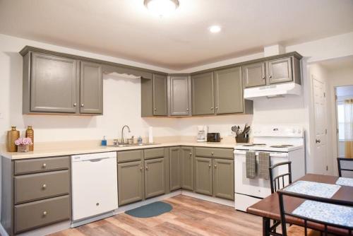 a kitchen with gray cabinets and a table and chairs at Relax & Feel At Home During Your Pittsburgh Stay in Pittsburgh