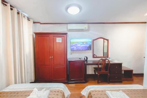 a bedroom with a desk and a red cabinet and a mirror at Khampiane1 Hotel in Ban Nongdouang