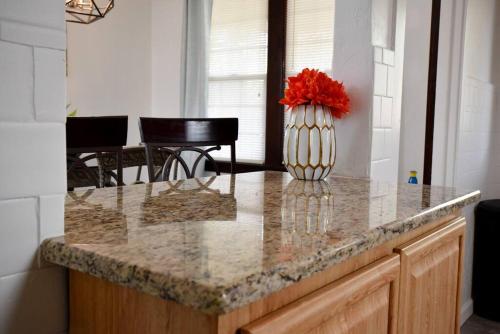 a vase with red flowers sitting on a kitchen counter at Beautiful 3 Bedroom Home Cozy Front and Back Porch in Munhall