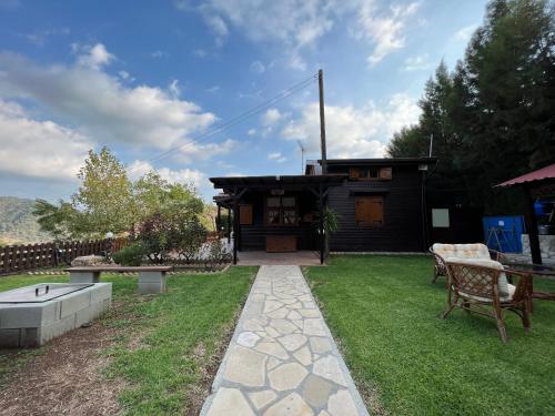 a house with a garden with a table and a patio at Kapilio Cottage House in Kapilio