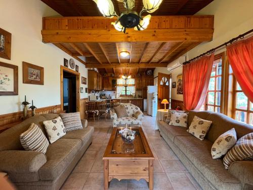 uma sala de estar com sofás e uma mesa em Kapilio Cottage House 