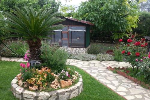 a garden with a garden path with flowers and a bird house at Kapilio Cottage House in Kapilio