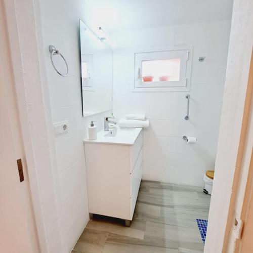 a white bathroom with a sink and a mirror at La Gardana, casa de campo mallorquina in Porreres