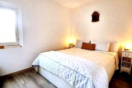 a small bedroom with a white bed and a window at La Gardana, casa de campo mallorquina in Porreres