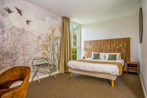 - une chambre avec un lit et un mur orné d'oiseaux dans l'établissement Les Jardins de l'Anjou, à La Pommeraye
