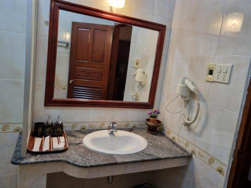 a bathroom with a sink and a mirror at Khampiane1 Hotel in Ban Nongdouang