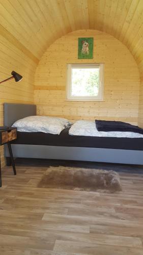a bedroom with a bed in a room with a window at Glamping Pod im Wald in Nordholz