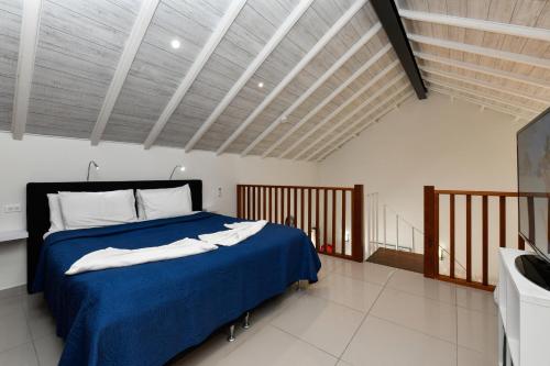 a bedroom with a bed with a blue comforter at Boutique Hotel Swiss Paradise Aruba Villas and Suites in Palm-Eagle Beach
