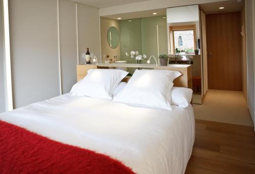 a large white bed with white pillows in a bedroom at Hotel Echaurren Relais & Châteaux in Ezcaray